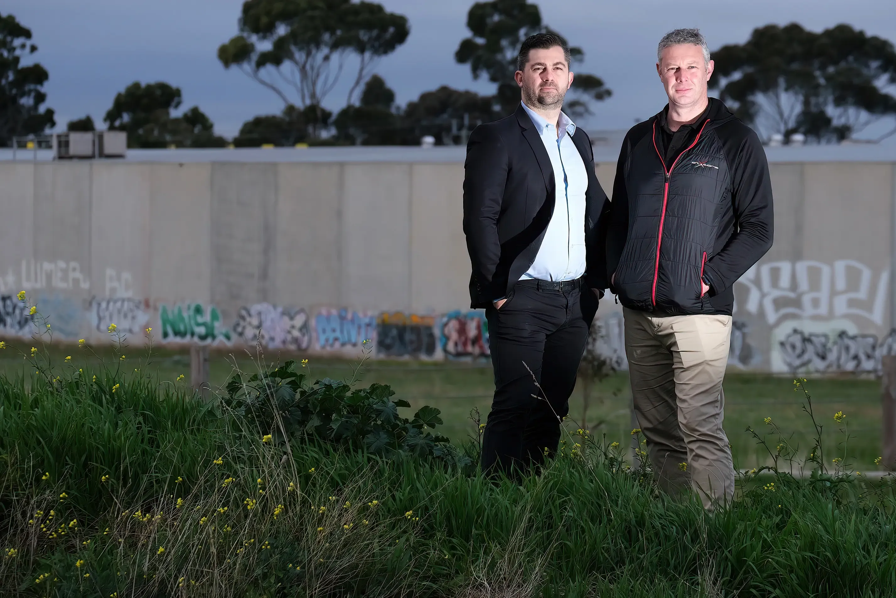 Two businesspeople photographed outdoors at dusk