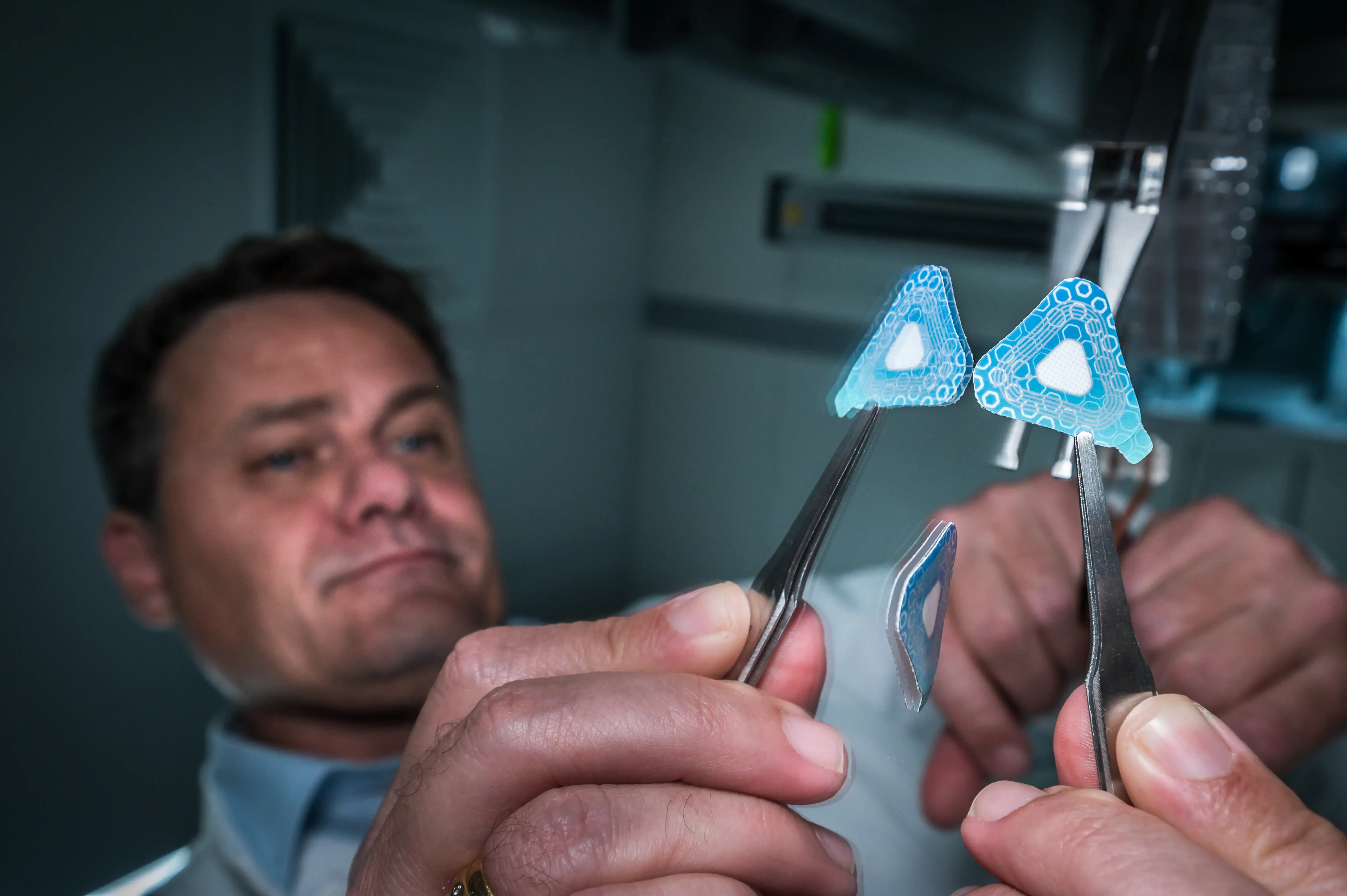 A researcher inspecting prototype wearable sensor patches